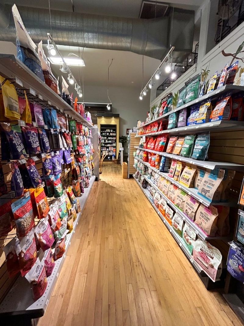 A long, narrow aisle lined floor to ceiling with bags of dog and cat food and treats